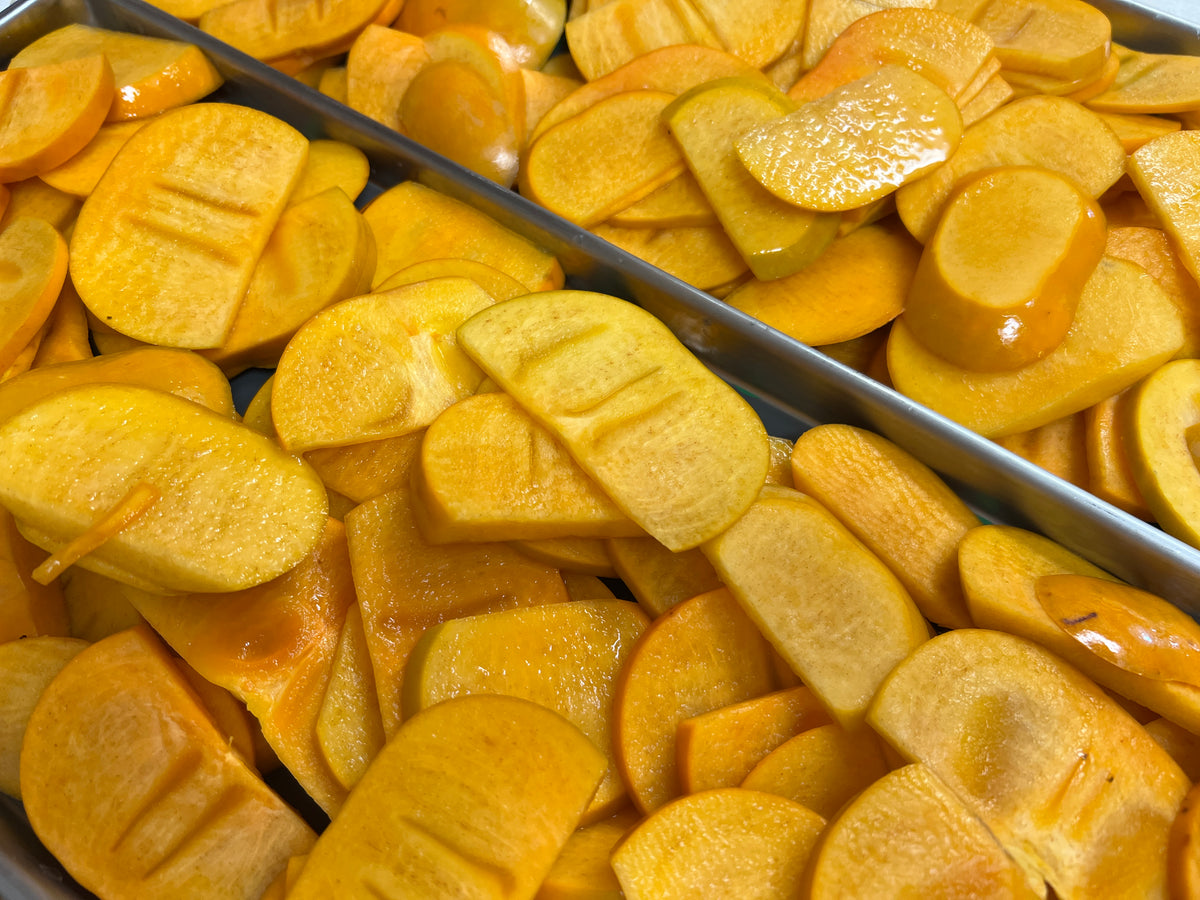 Sliced persimmons on a freeze dryer tray before drying